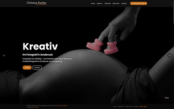 Eine Hand platziert kleine Babyschuhe auf einem schwangeren Bauch. Der Hintergrund ist unscharf, und der Fokus liegt auf der Intimität des Moments. Der Bildschirm enthält Text über Fotografie und kreative Dienstleistungen in Innsbruck. Die Atmosphäre vermittelt Vorfreude und Verbundenheit.